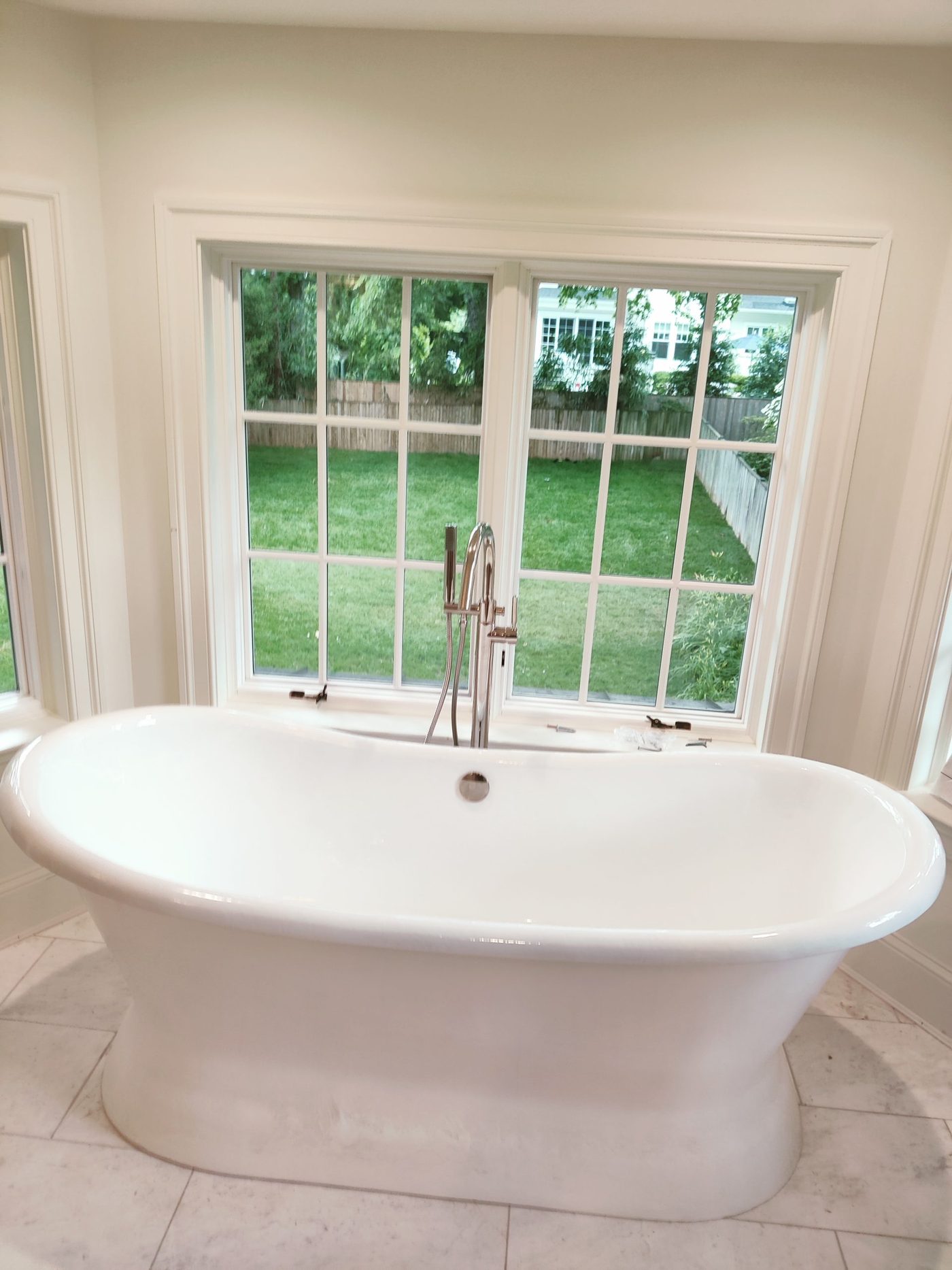 Finished bathroom remodel with freestanding tub and floor-mounted filler